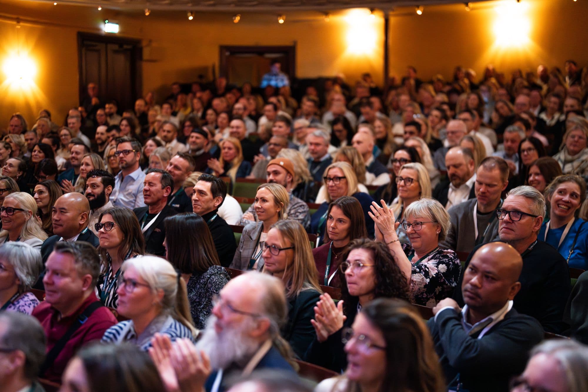 Fullsatt sal som applåderar